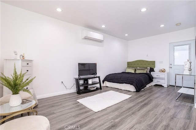 bedroom with wood-type flooring and a wall unit AC