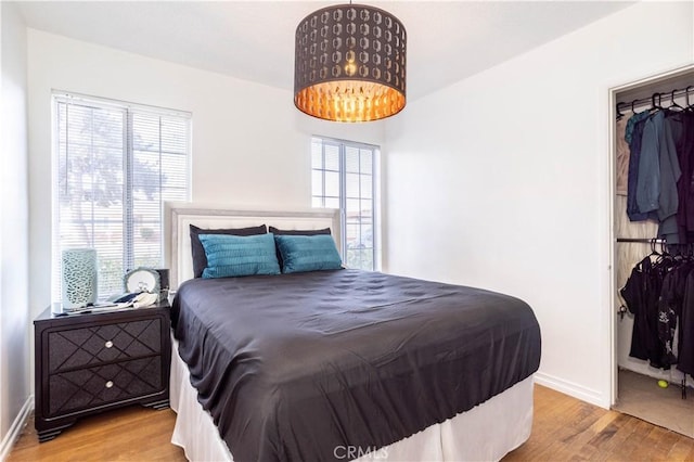 bedroom with an inviting chandelier and light wood-type flooring