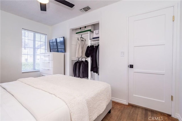 bedroom with ceiling fan, dark hardwood / wood-style floors, and a closet