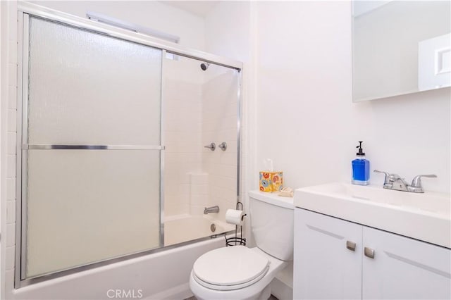 full bathroom featuring toilet, vanity, and shower / bath combination with glass door