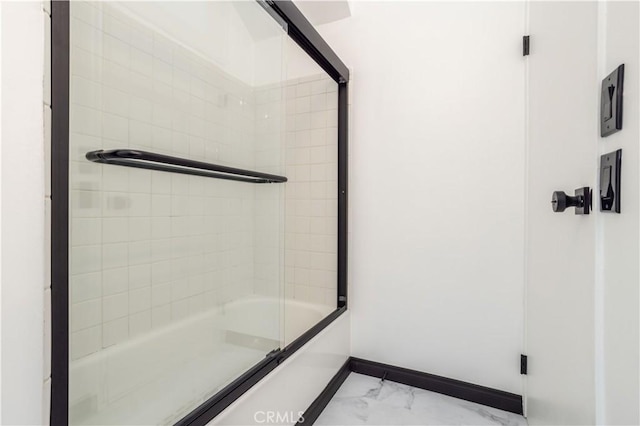 bathroom featuring combined bath / shower with glass door