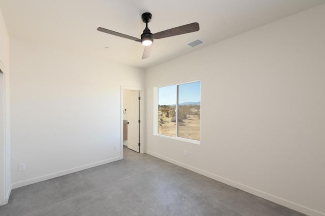 spare room with ceiling fan and concrete floors