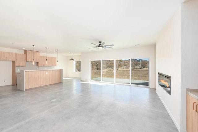 unfurnished living room with ceiling fan