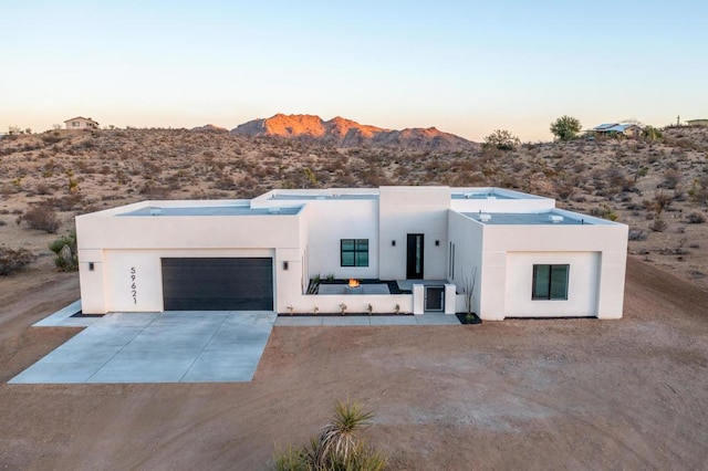 view of front of home with a mountain view and a garage