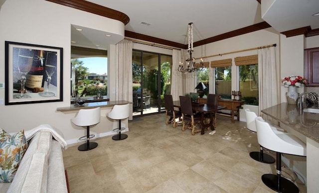 dining space featuring an inviting chandelier, crown molding, and sink