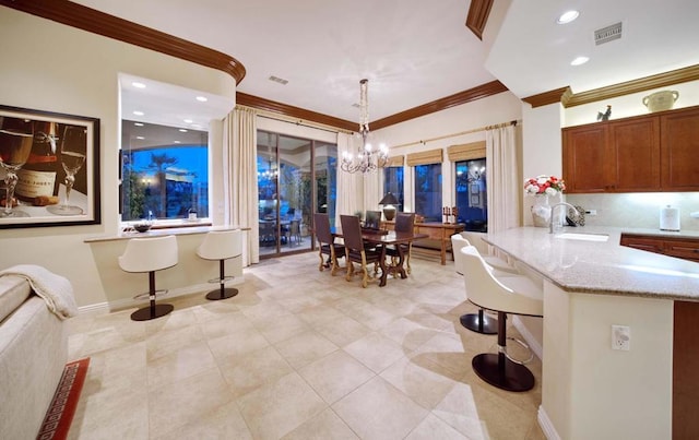 tiled dining area with an inviting chandelier, crown molding, and sink