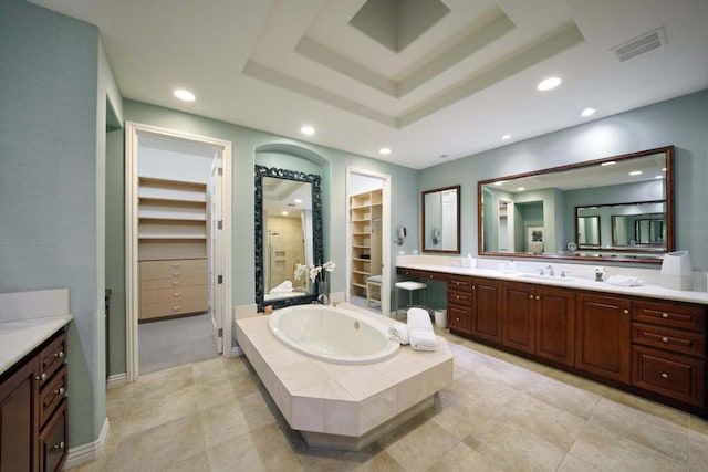 bathroom with a raised ceiling, tile patterned flooring, and vanity