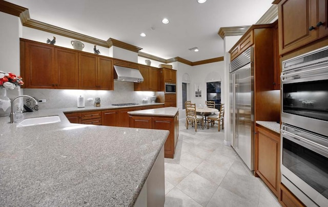 kitchen with a center island, sink, wall chimney range hood, decorative backsplash, and black appliances