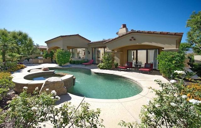 rear view of house featuring a patio area and a pool with hot tub