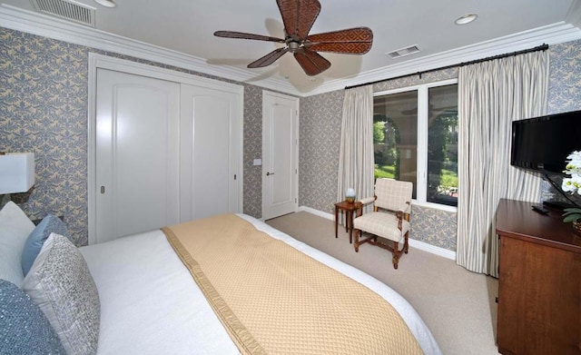 bedroom featuring a closet, ceiling fan, crown molding, and carpet