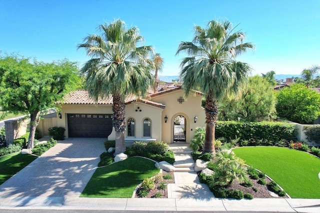 mediterranean / spanish-style home with a front yard and a garage