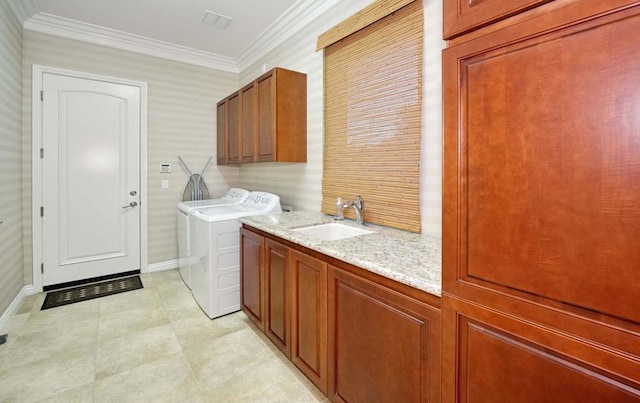 washroom featuring separate washer and dryer, sink, cabinets, and ornamental molding