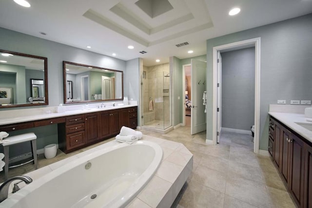 bathroom featuring tile patterned flooring, vanity, a tray ceiling, and separate shower and tub