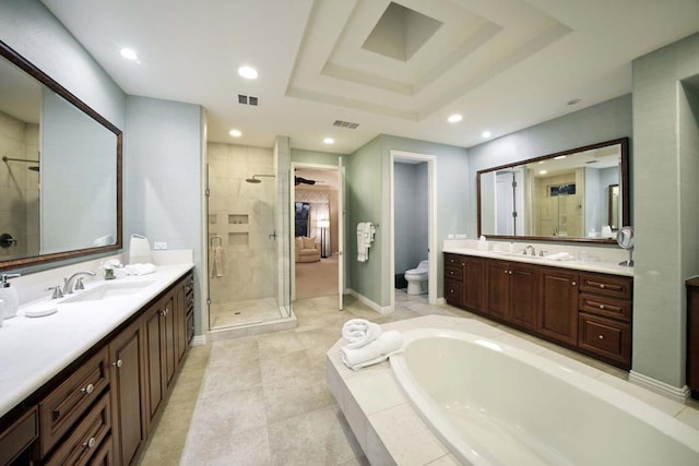 full bathroom featuring a tray ceiling, vanity, independent shower and bath, and toilet