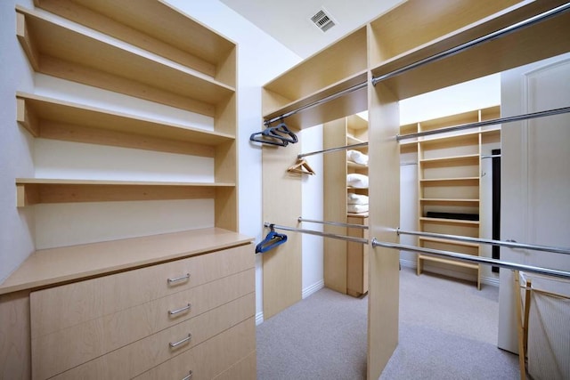 walk in closet with light colored carpet