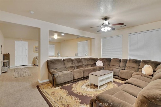 carpeted living room with a textured ceiling and ceiling fan