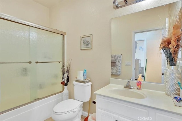 full bathroom with toilet, bath / shower combo with glass door, and vanity