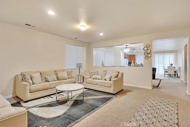 carpeted living room featuring ceiling fan