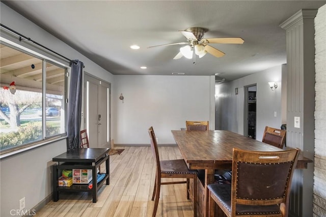 dining space featuring light hardwood / wood-style floors, ornate columns, and ceiling fan