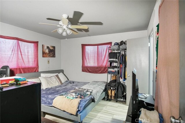 bedroom featuring light wood-type flooring, ceiling fan, and a closet