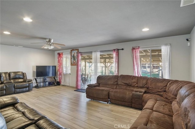 living room featuring ceiling fan and light hardwood / wood-style floors