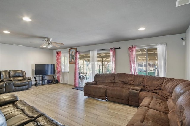 living room with ceiling fan and light wood-type flooring