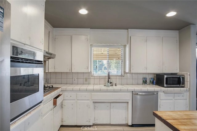 kitchen featuring sink, white cabinetry, appliances with stainless steel finishes, and tile countertops