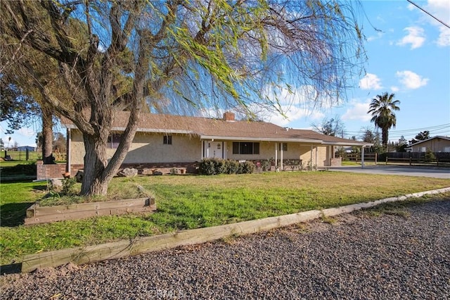 view of front of property featuring a front lawn and a carport