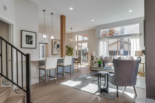 dining area with a high ceiling, an inviting chandelier, and light hardwood / wood-style floors