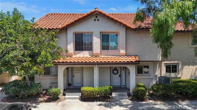 mediterranean / spanish-style house with covered porch and central AC