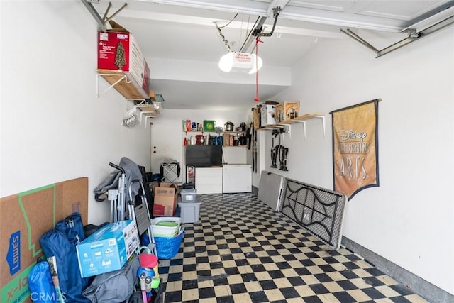 garage featuring white refrigerator and a garage door opener