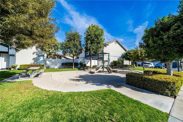 view of home's community with a playground and a lawn