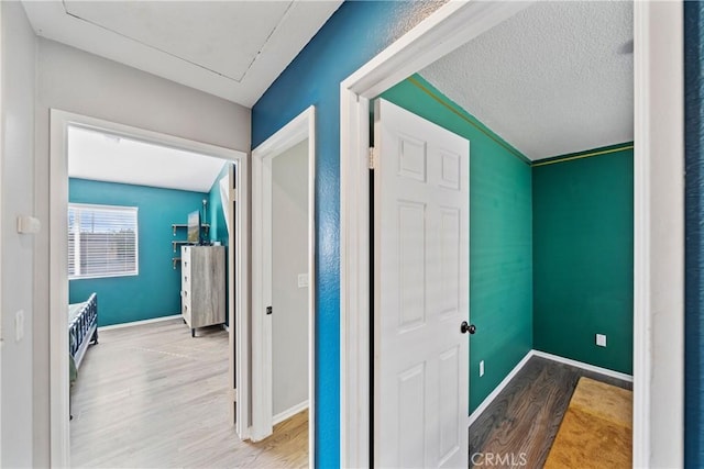 corridor featuring light hardwood / wood-style floors and a textured ceiling