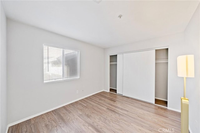 unfurnished bedroom with a closet and light hardwood / wood-style flooring