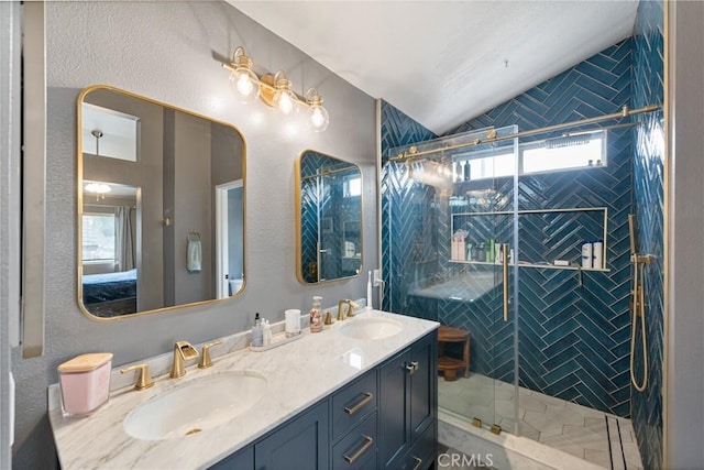 bathroom with lofted ceiling, vanity, and a tile shower