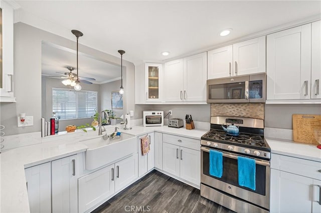 kitchen featuring appliances with stainless steel finishes, white cabinets, hanging light fixtures, and sink