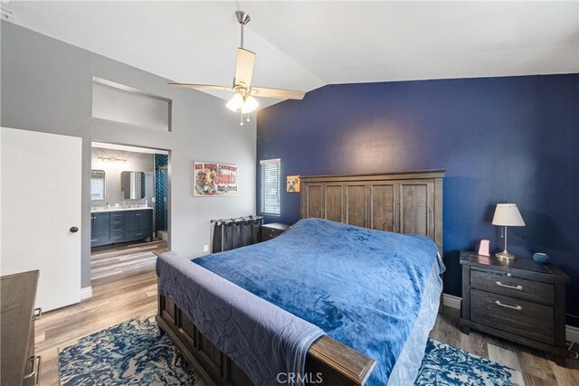 bedroom featuring ceiling fan, hardwood / wood-style floors, ensuite bathroom, and lofted ceiling