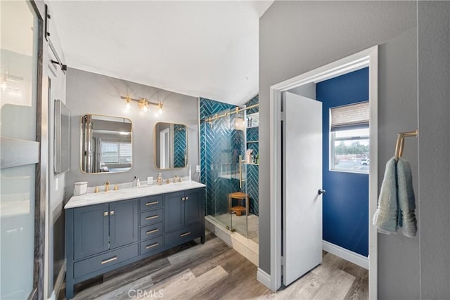 bathroom with a shower with shower door, wood-type flooring, and vanity