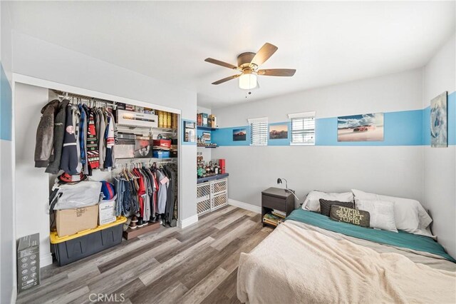 bedroom featuring ceiling fan, wood-type flooring, and a closet