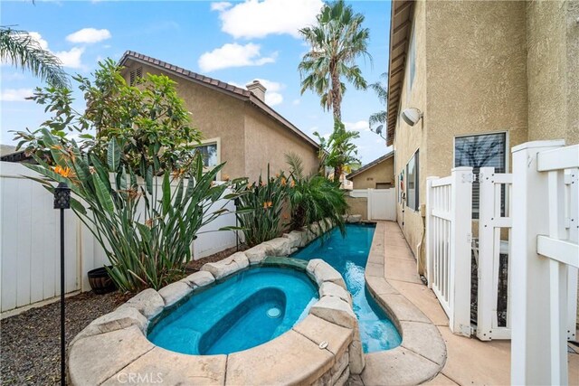 view of swimming pool with an in ground hot tub