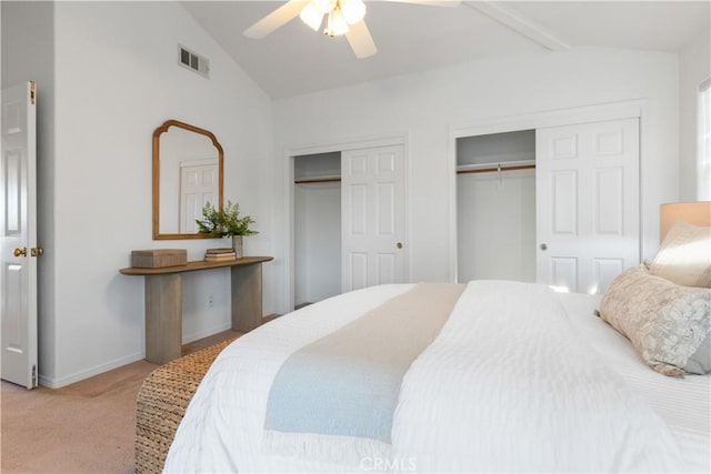 carpeted bedroom featuring lofted ceiling with beams, two closets, and ceiling fan