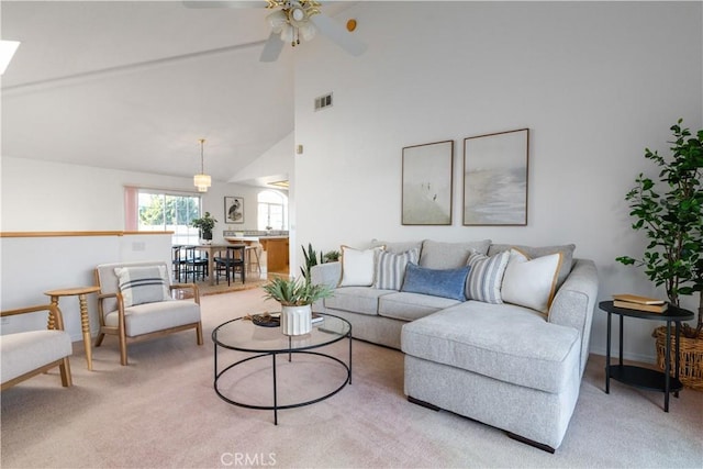 living room featuring high vaulted ceiling, light colored carpet, and ceiling fan