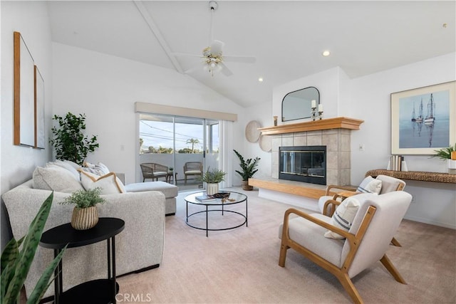 living room with a tile fireplace, high vaulted ceiling, light colored carpet, and ceiling fan