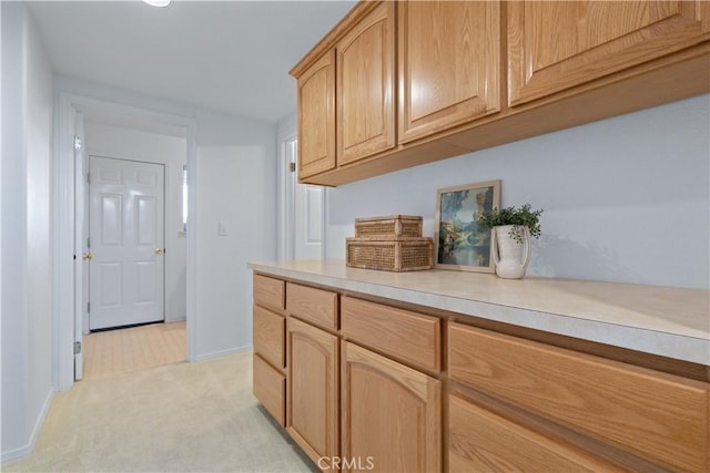 kitchen with light carpet and light brown cabinets