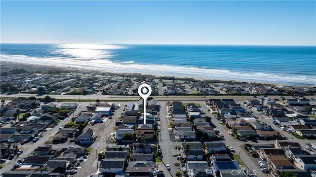 drone / aerial view with a water view and a beach view