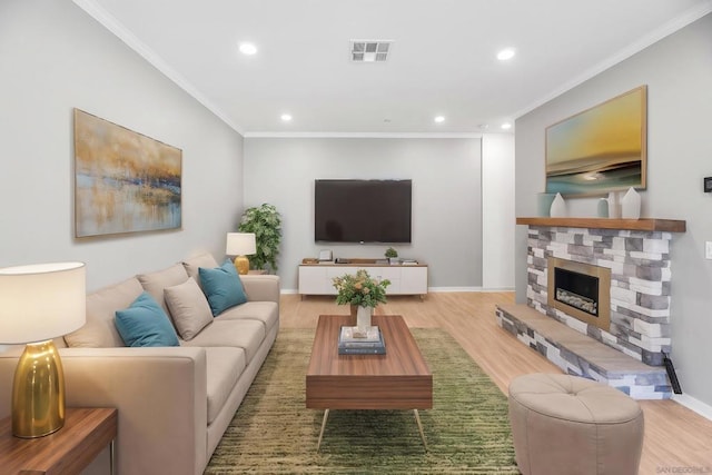 living room with a fireplace, crown molding, and light hardwood / wood-style floors