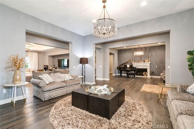 living room with dark hardwood / wood-style flooring and a notable chandelier