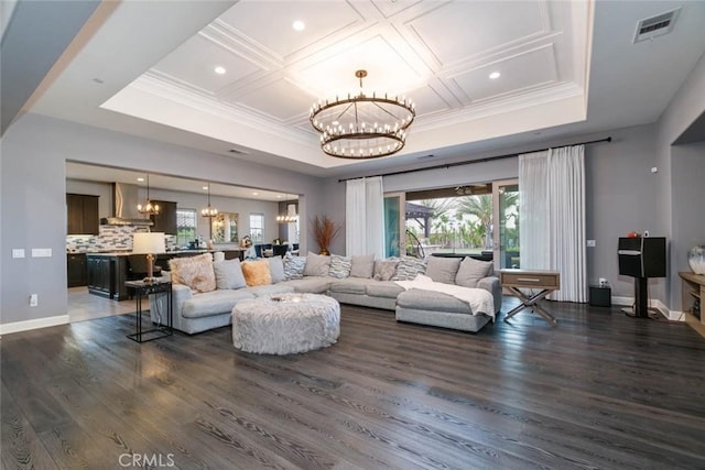 living room with plenty of natural light, dark hardwood / wood-style flooring, and an inviting chandelier