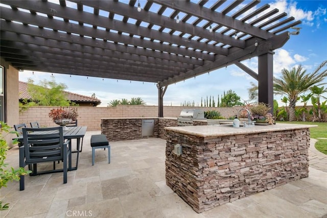 view of patio featuring a pergola, a grill, exterior kitchen, and sink