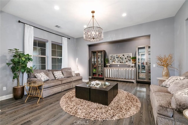 living room featuring dark wood-type flooring and a notable chandelier